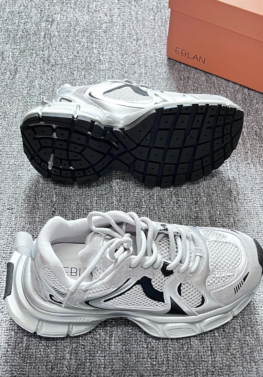 Metallic mesh retro runner sneakers showing rugged sculpted outsole and silver black side profile