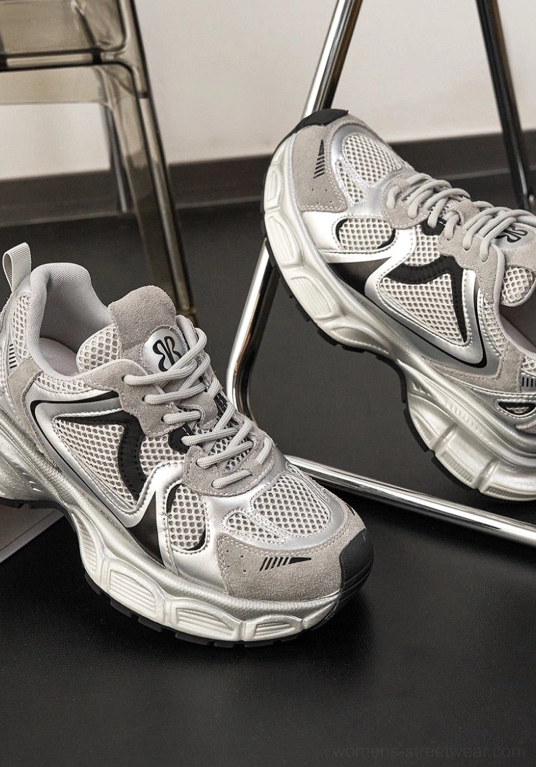 Pair of silver grey metallic mesh retro runner sneakers with black accents displayed from an angled top view