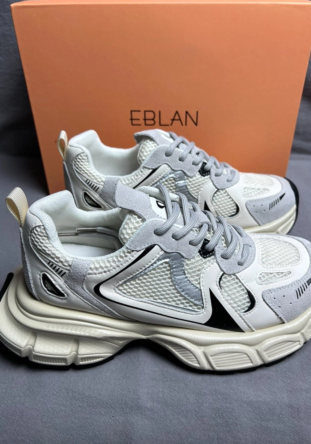 White and silver metallic mesh retro runner sneaker with black decorative stripes and thick sculpted midsole