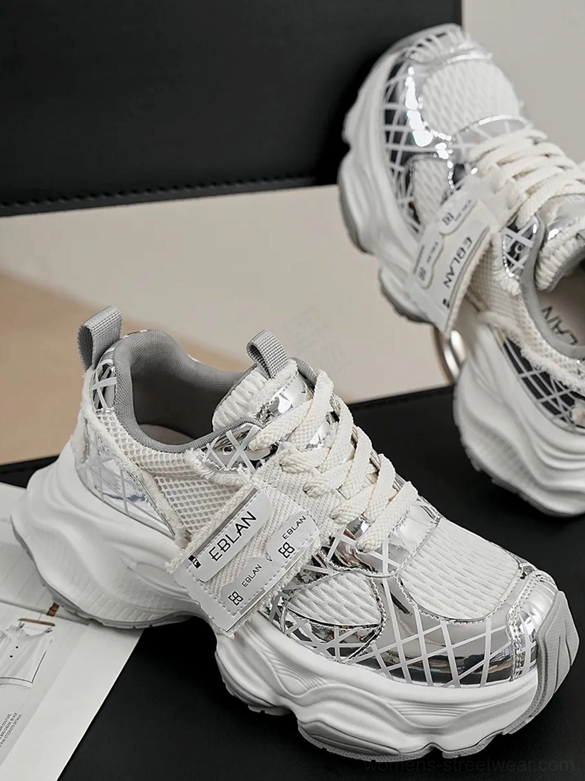 Metallic silver mesh chunky sneakers with lace-up front, textured grid panels, reflective overlays, adjustable strap detail, and bold futuristic streetwear silhouette