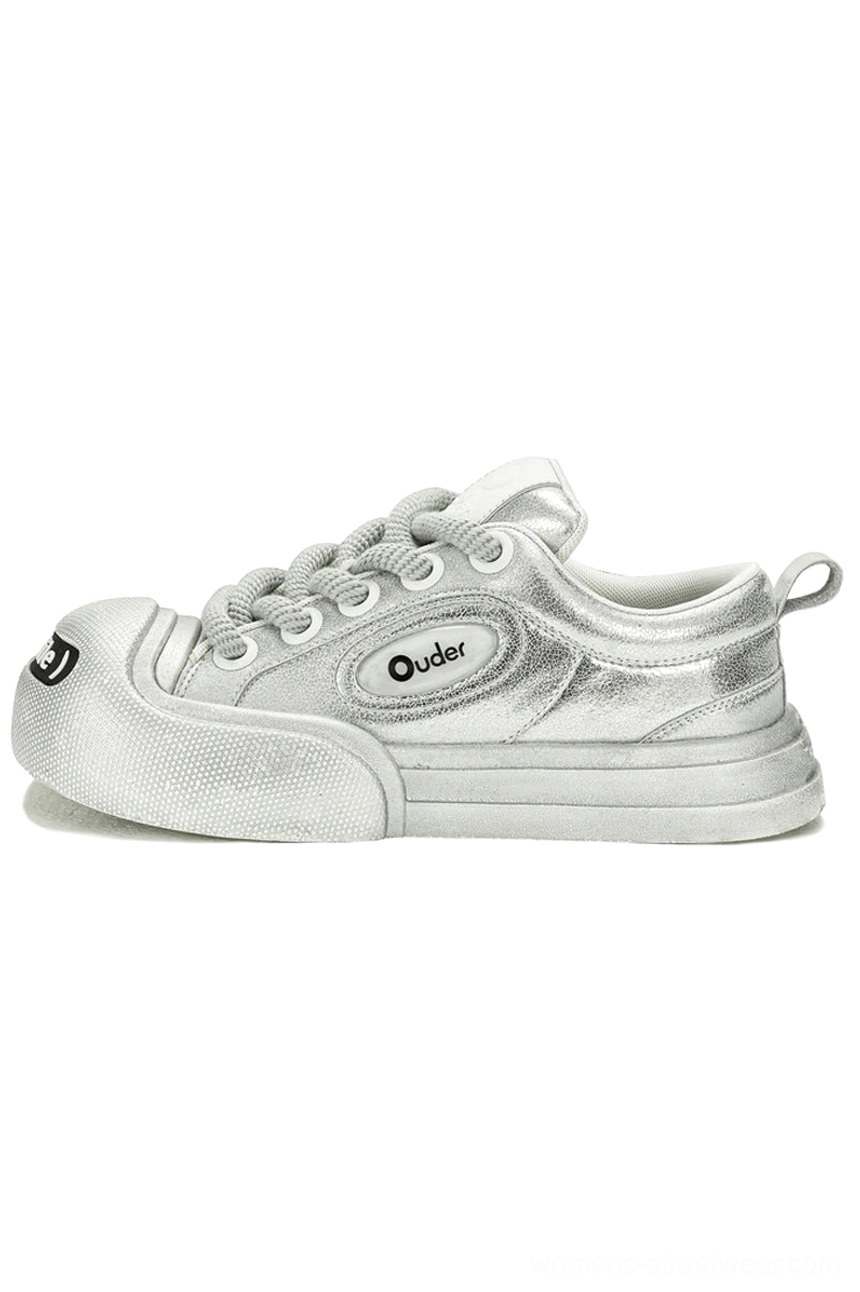 Metallic silver platform canvas sneaker shown from the side with chunky sole, textured toe bumper, heel pull tab, and streetwear design