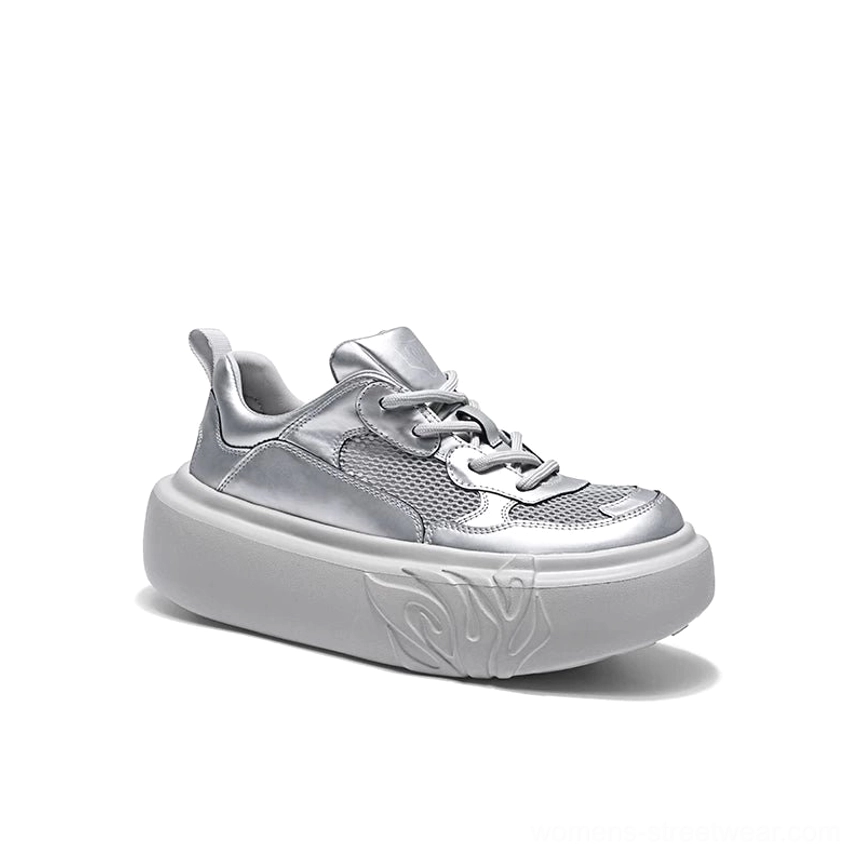 Front three-quarter view of metallic silver platform sneaker with reflective upper, mesh panels, lace-up front, and flame sole