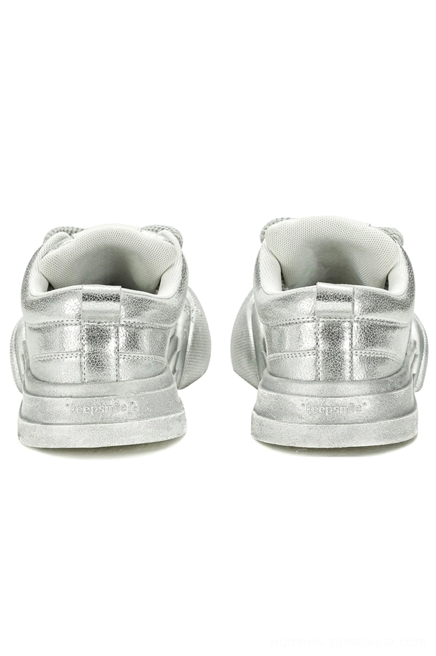 Rear view of metallic silver platform sneakers showing heel panels, pull tabs, branded heel detailing, and chunky elevated soles