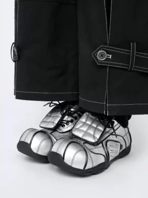High-angle view of metallic silver quilted foldover-tongue sneakers styled with black contrast-stitch cargo pants and black socks