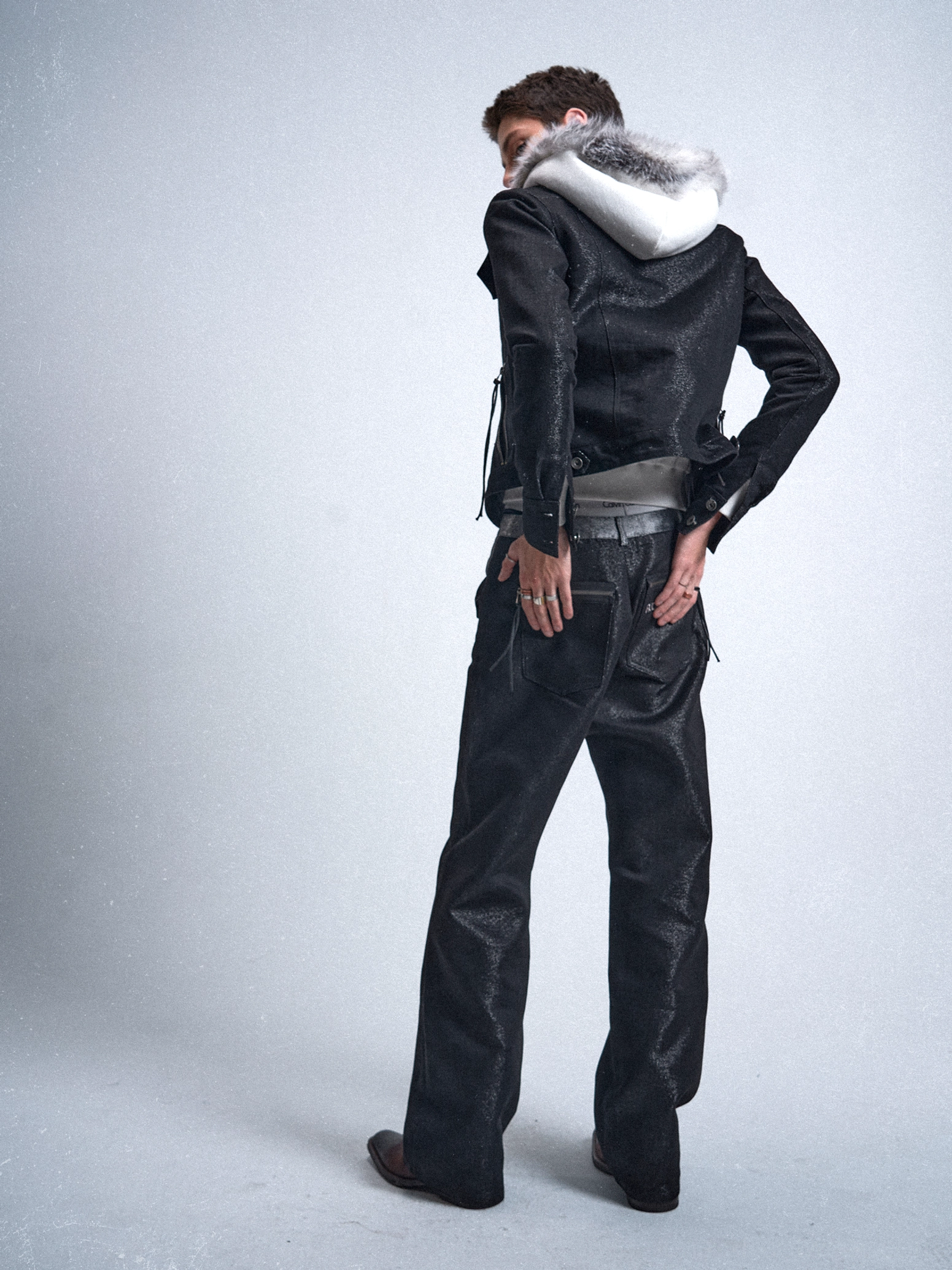Back three-quarter view of black metallic straight jeans showing the relaxed straight leg and rear pocket design