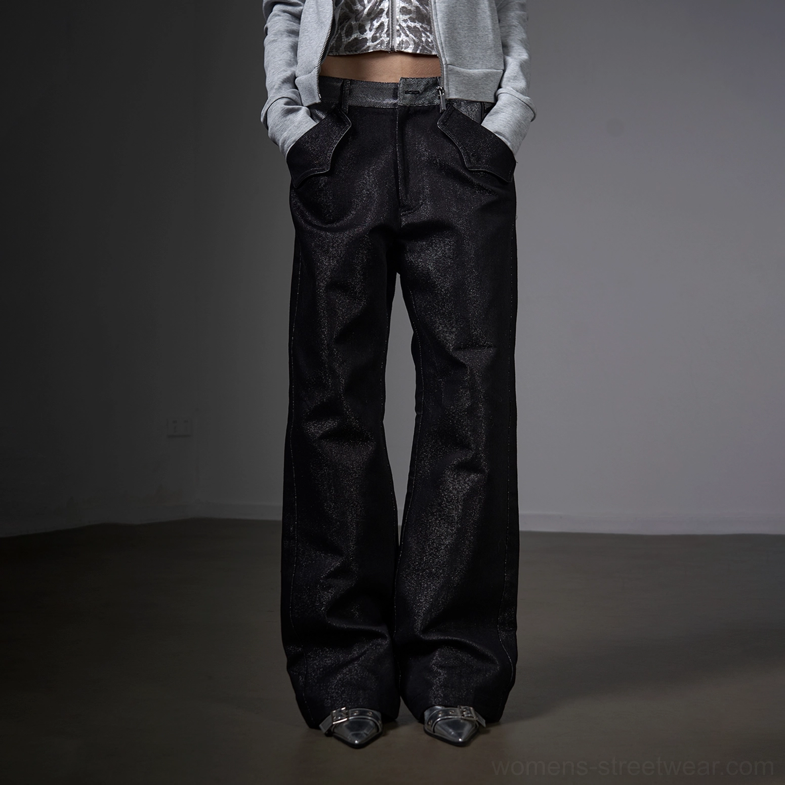 Low-angle front view of black metallic silver yarn raw straight jeans with a glossy textured finish and pointed shoes