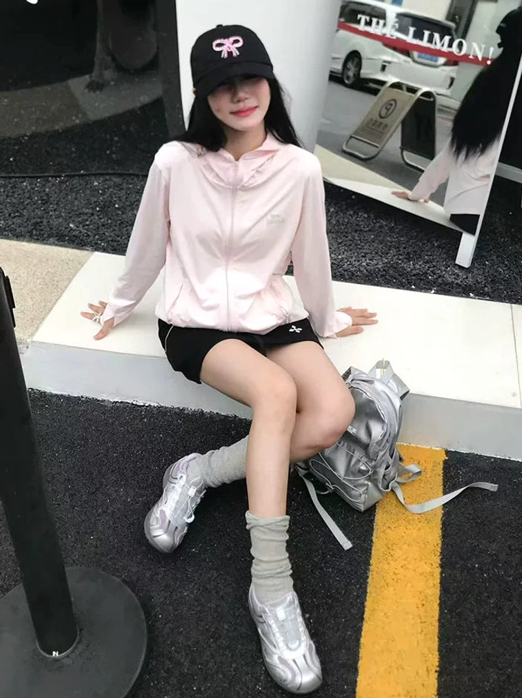Female streetwear outfit styling silver gray streamline trail sneakers with pink jacket black shorts and rolled socks