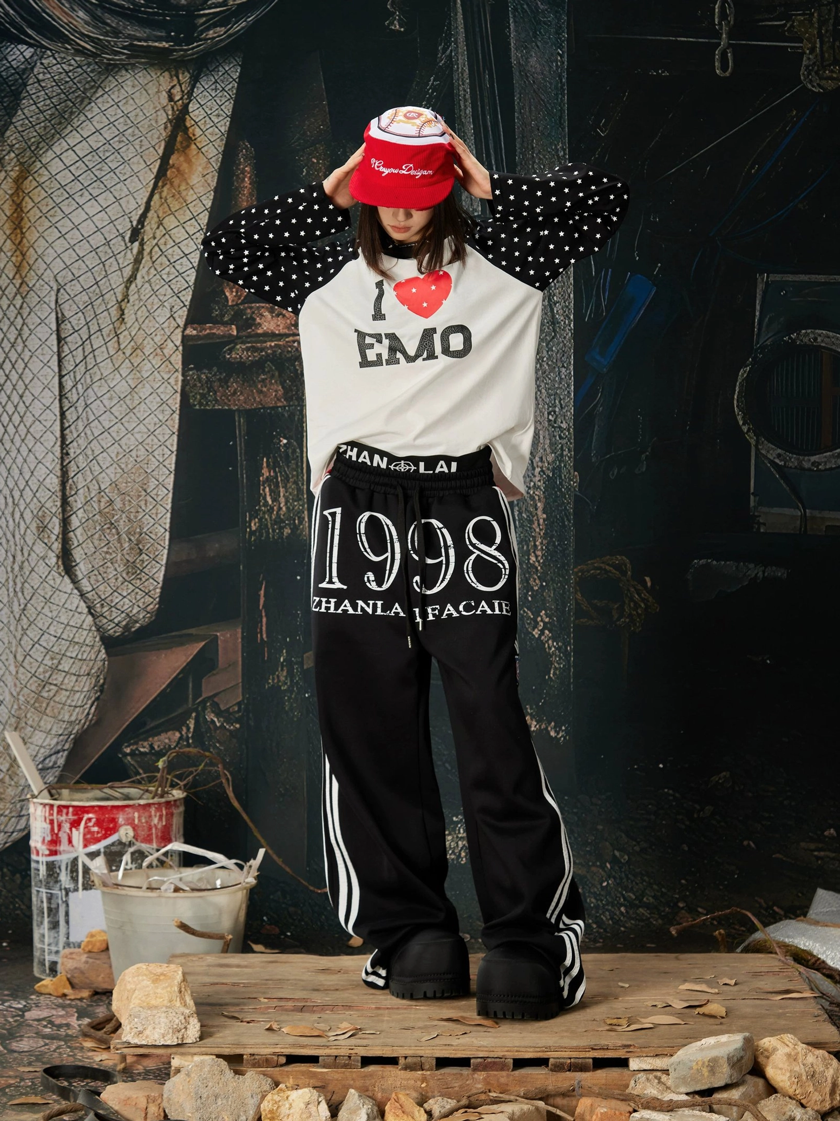 Front streetwear outfit with black 1998 graphic wide-leg sweatpants, white side stripes, and contrasting patchwork sleeve top