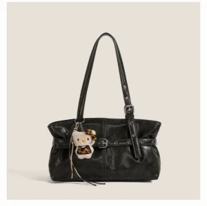 Black faux leather buckle shoulder bag with ruched sides, silver hardware, and playful cat pendant on a neutral studio background