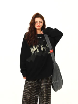 Black oversized Midnight Crowd graphic sweatshirt with faded crowd print, dropped shoulders, and checkered wide-leg streetwear pants