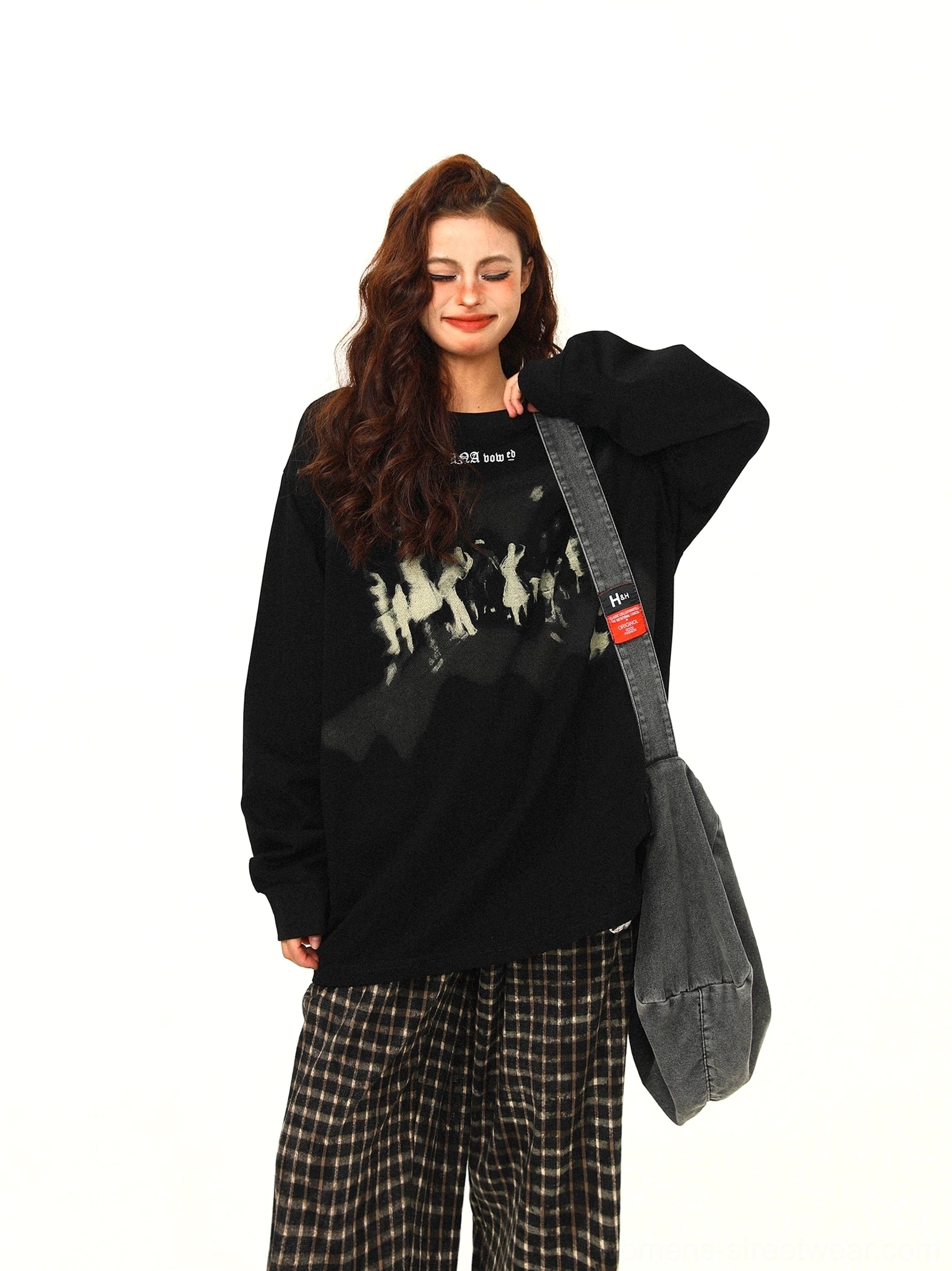 Black oversized Midnight Crowd graphic sweatshirt with faded crowd print, dropped shoulders, and checkered wide-leg streetwear pants