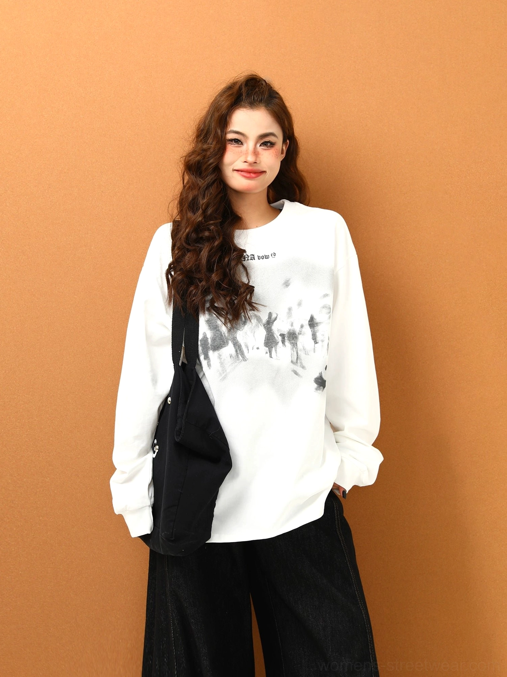 White oversized graphic sweatshirt with gray faded crowd print, classic crew neckline, and black wide-leg streetwear trousers
