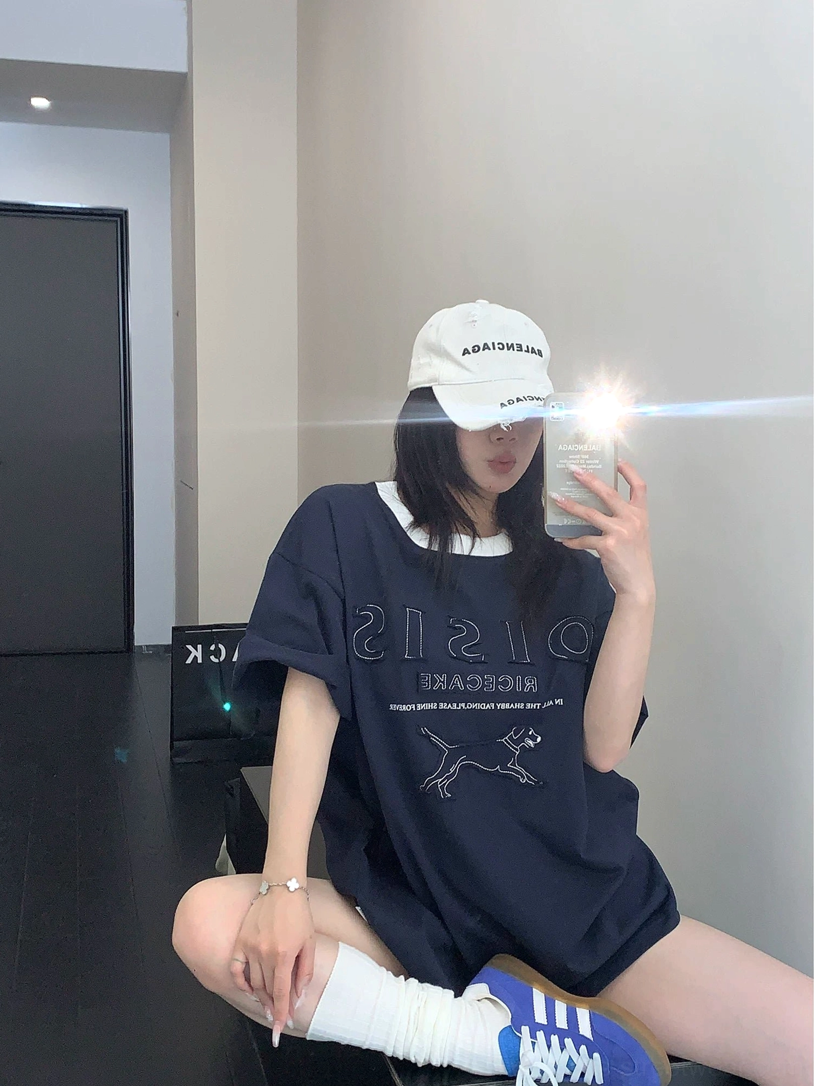 Back view of navy blue oversized hound streetwear tee styled with white socks and blue retro sneakers