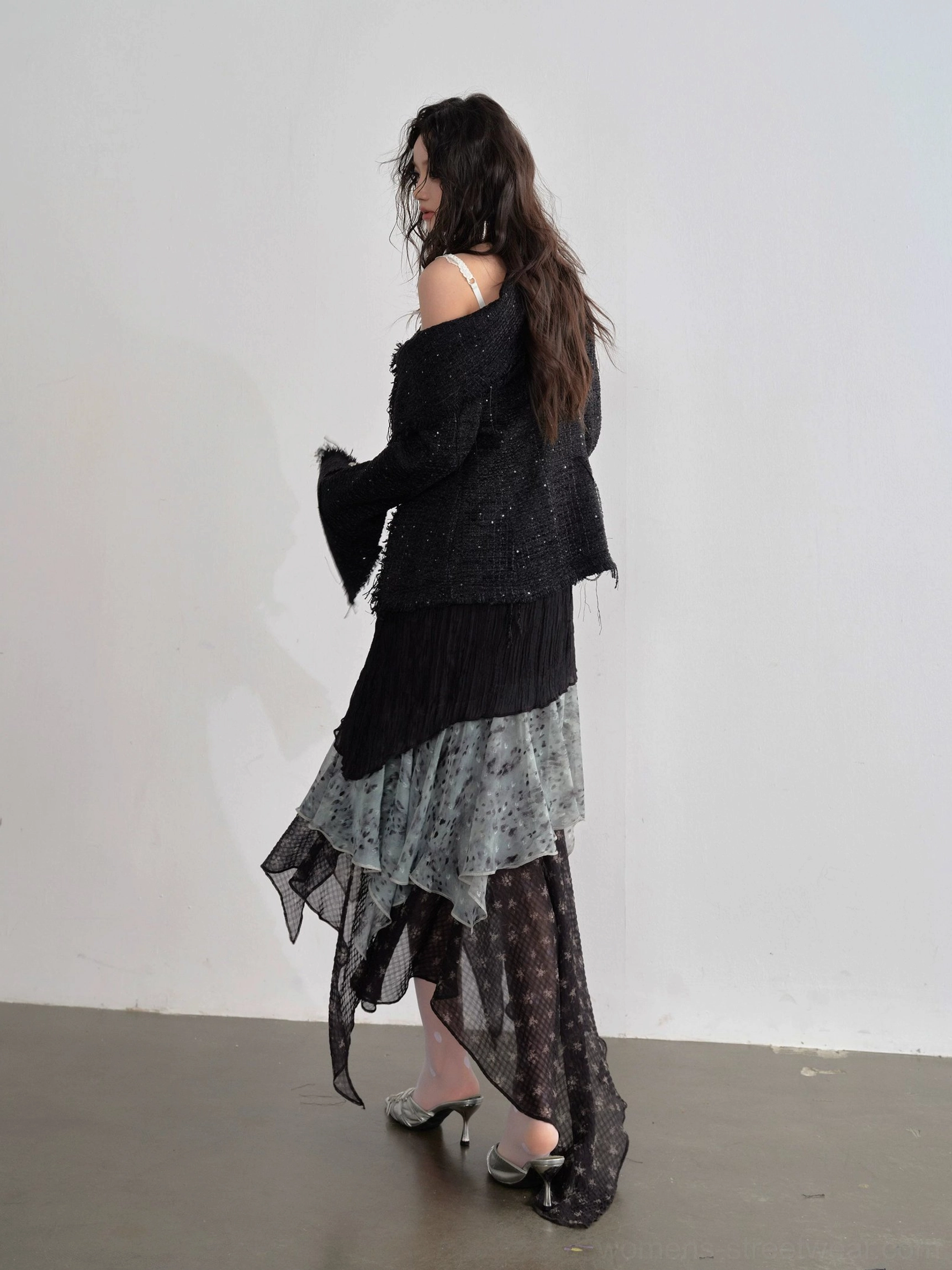 Side back view of black layered handkerchief hem maxi skirt showing lightweight chiffon movement and asymmetrical drape