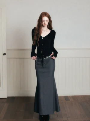 Black slim-fit long-sleeve V-neck ribbed cardigan top styled with a high-waisted gray mermaid maxi skirt and waist chain