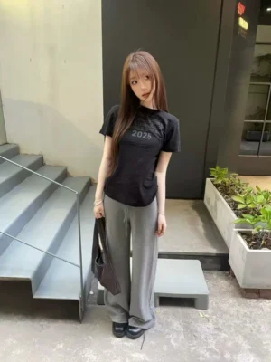 Black Midnight Outcome 2025 graphic tee styled with gray wide-leg trousers in a modern Seoul streetwear outfit