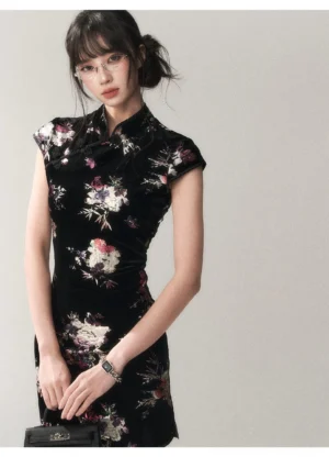Short black velvet cheongsam dress with colorful peony floral print, Mandarin stand collar, cap sleeves, fitted bodycon silhouette, model wearing glasses with a mini black handbag