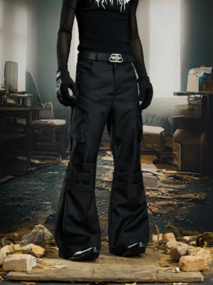 Front full-body view of black stacked cargo flare streetwear pants styled in a dark industrial studio
