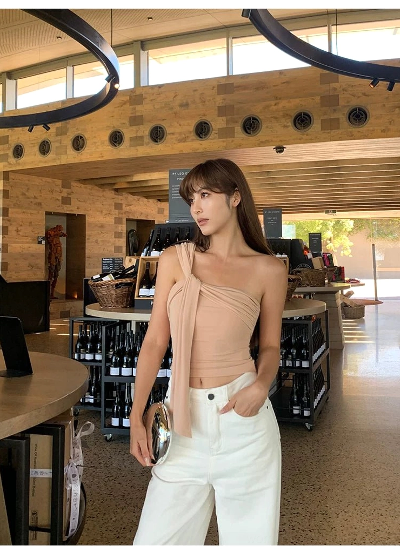 Milk Tea beige asymmetric crop top styled with white wide-leg trousers in a polished contemporary outfit