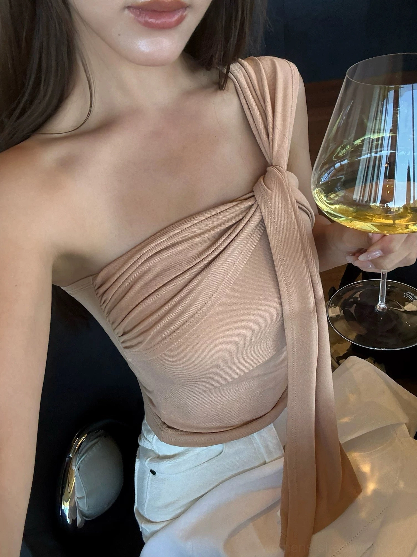 Milk Tea beige asymmetric draped one-shoulder crop top with long shoulder sash and soft stretch fit styled for an elegant evening