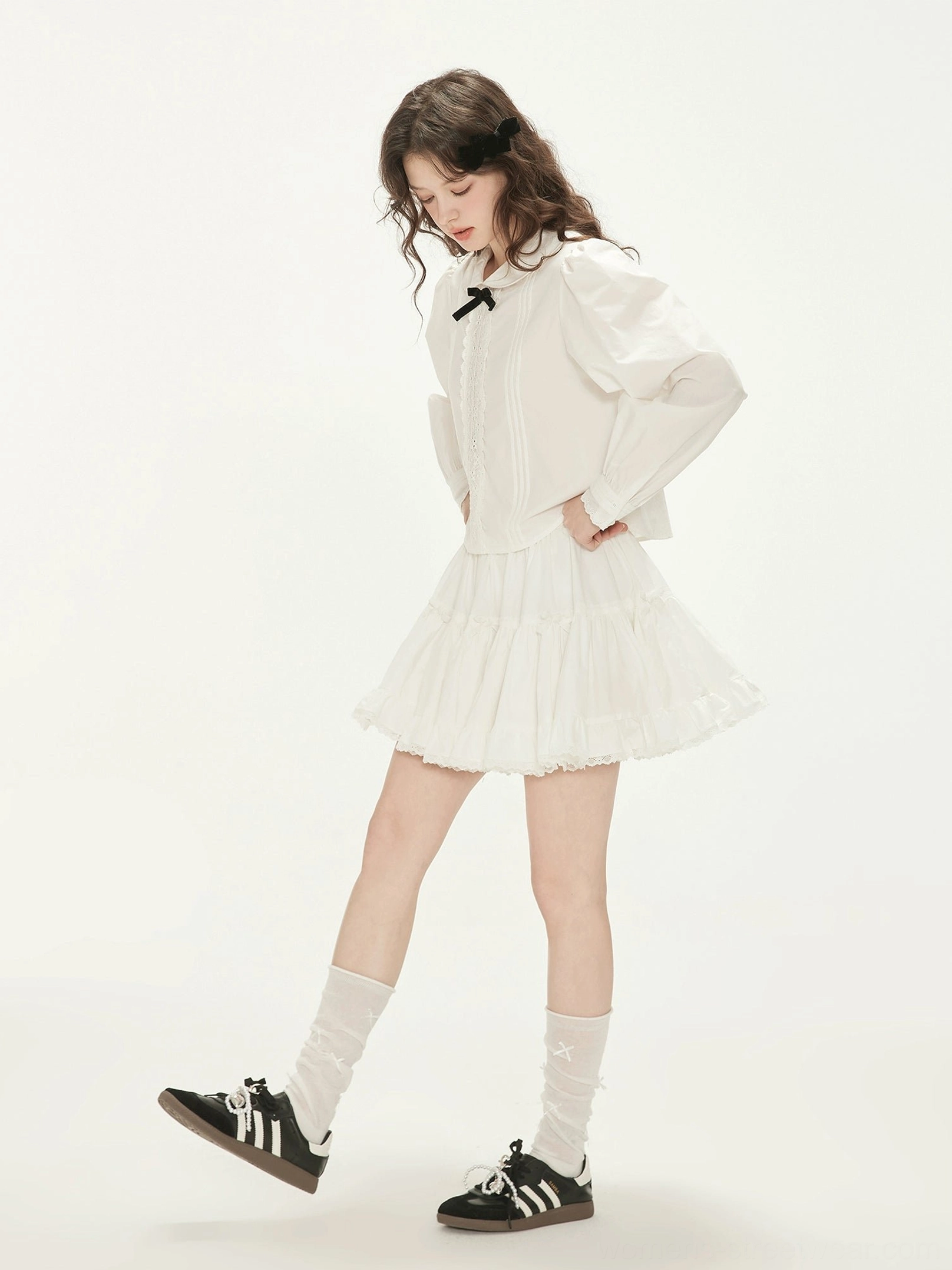 Milk white long sleeve Peter Pan collar blouse with black bow and ruffle mini skirt front three quarter view