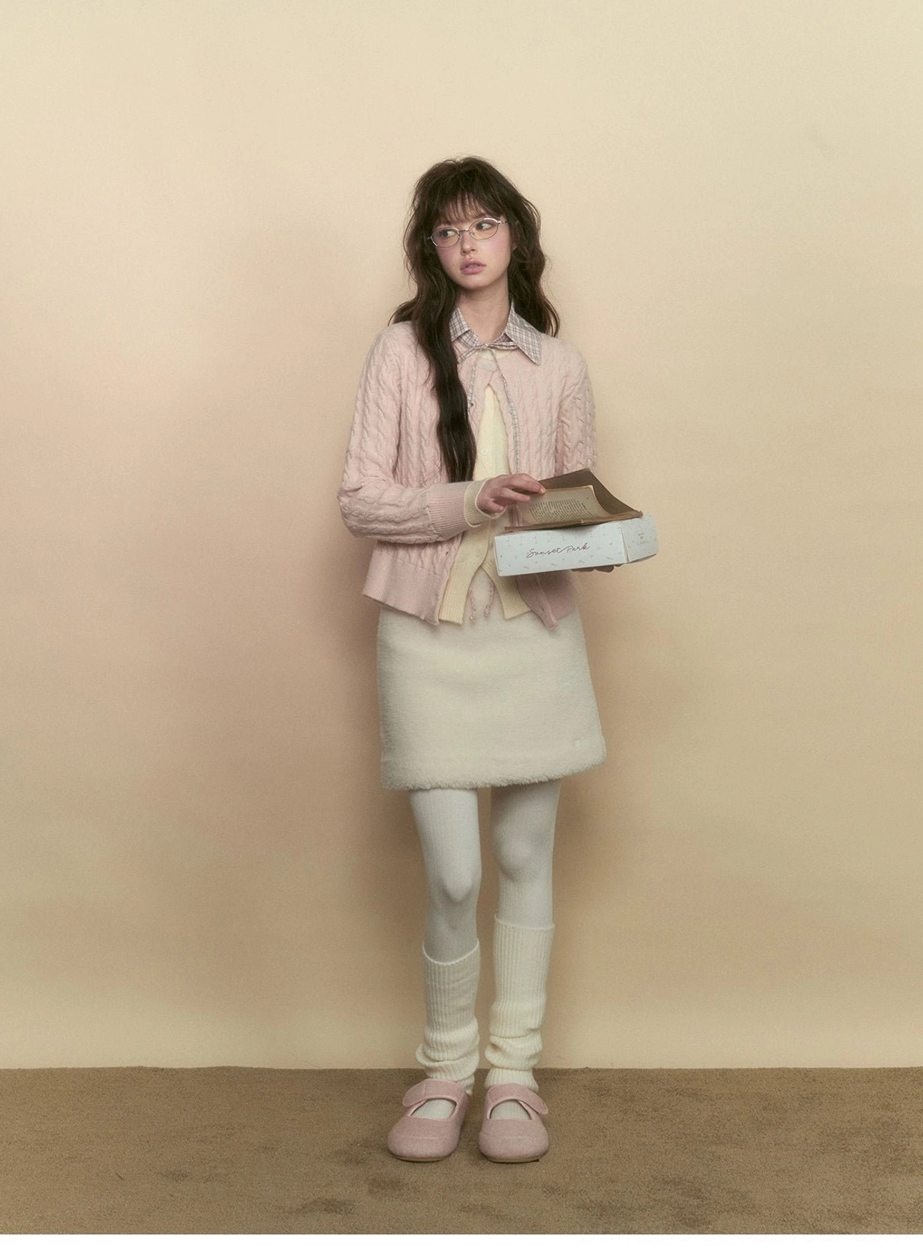 Milky pink button front cable knit cardigan layered over a plaid collar top for a Korean preppy streetwear look