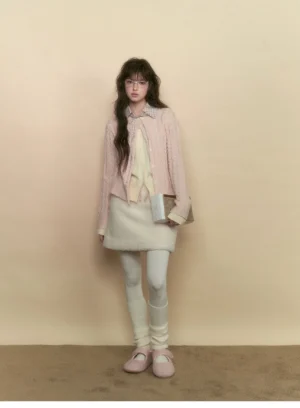 Full body view of milky pink cable knit preppy cardigan with an ivory mini skirt in a soft academia outfit