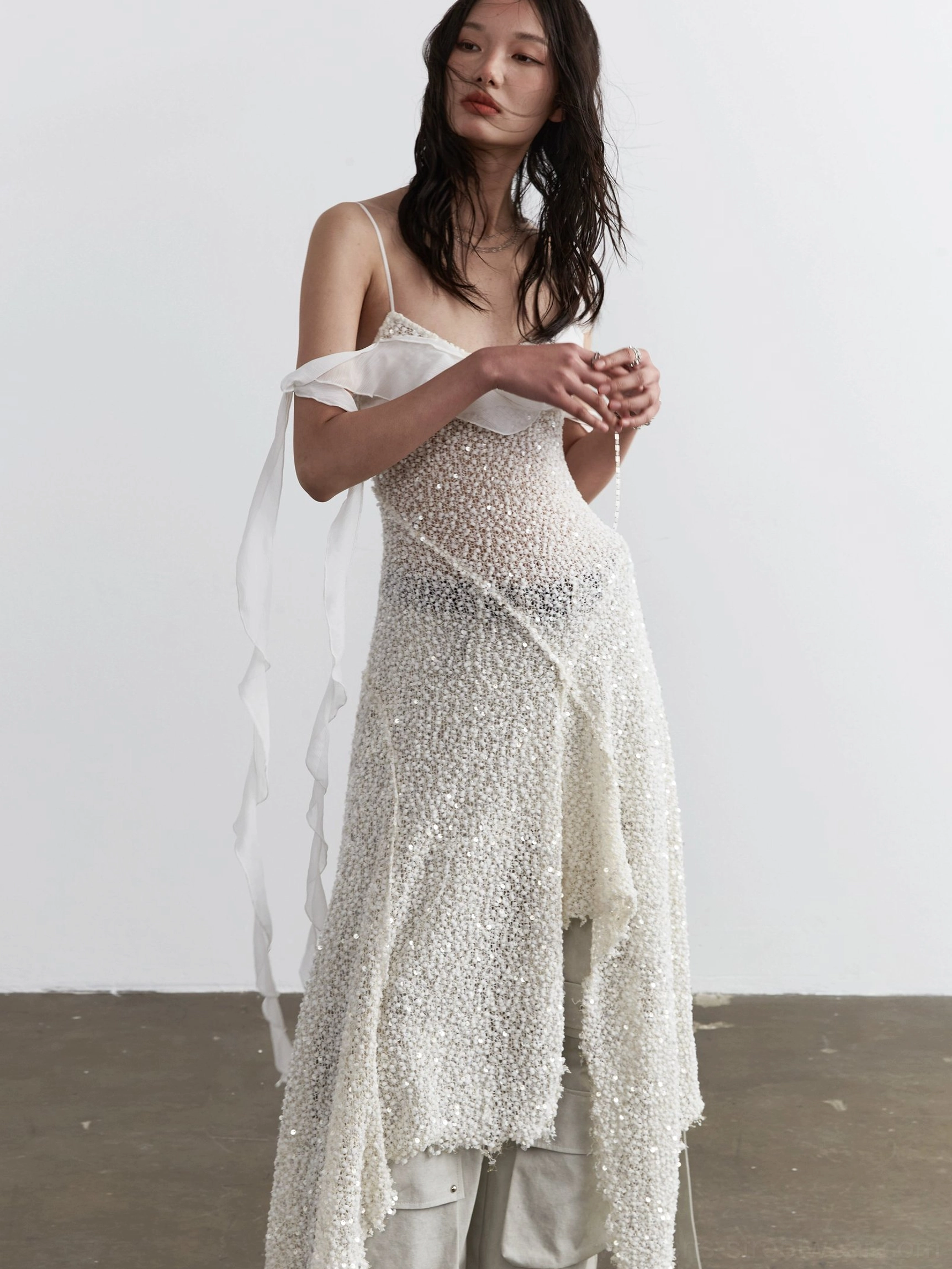 Close front view of milky white sequin slip dress with thin spaghetti straps and ruffled sweetheart neckline