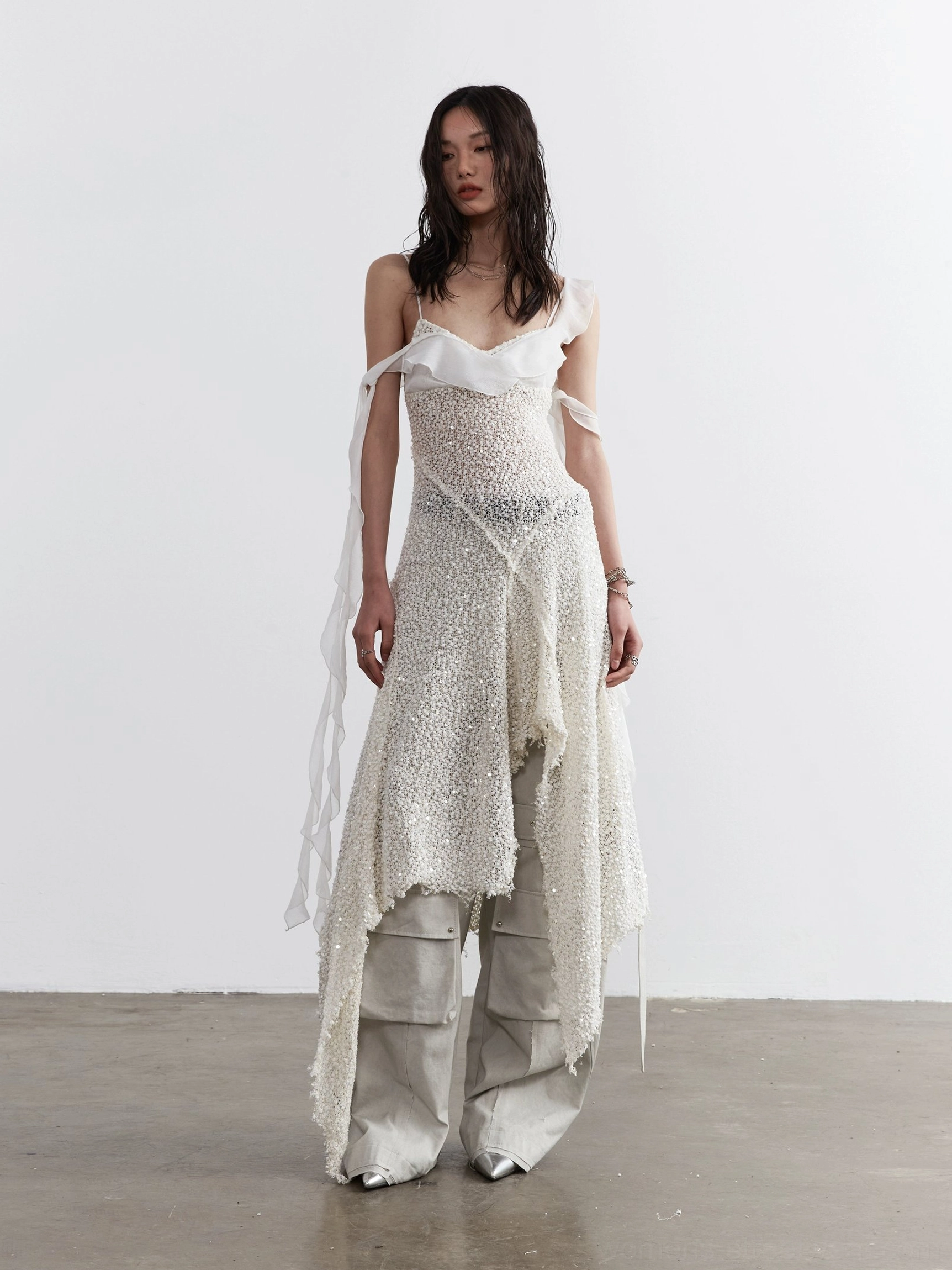 Milky white sequined layered dress styled over cargo pants in a full front Seoul streetwear outfit view
