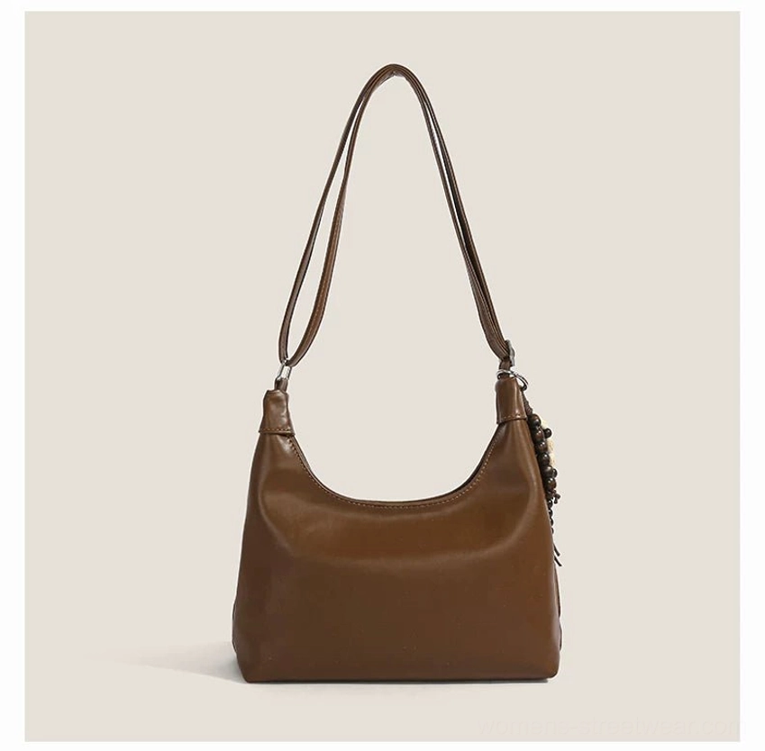 Minimal smooth brown hobo shoulder bag with curved crescent silhouette and simple strap front view