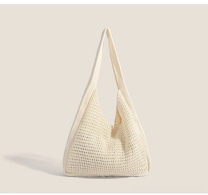 Minimal off white crochet hobo shoulder bag with solid woven texture, curved silhouette, and wide fabric strap