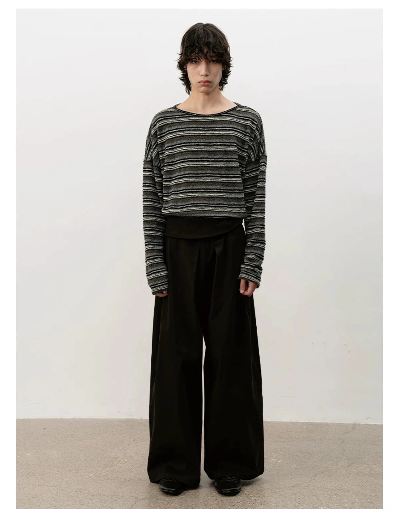 Front view of minimalist black leather ballet sneakers completing a neutral oversized wide-leg trouser outfit