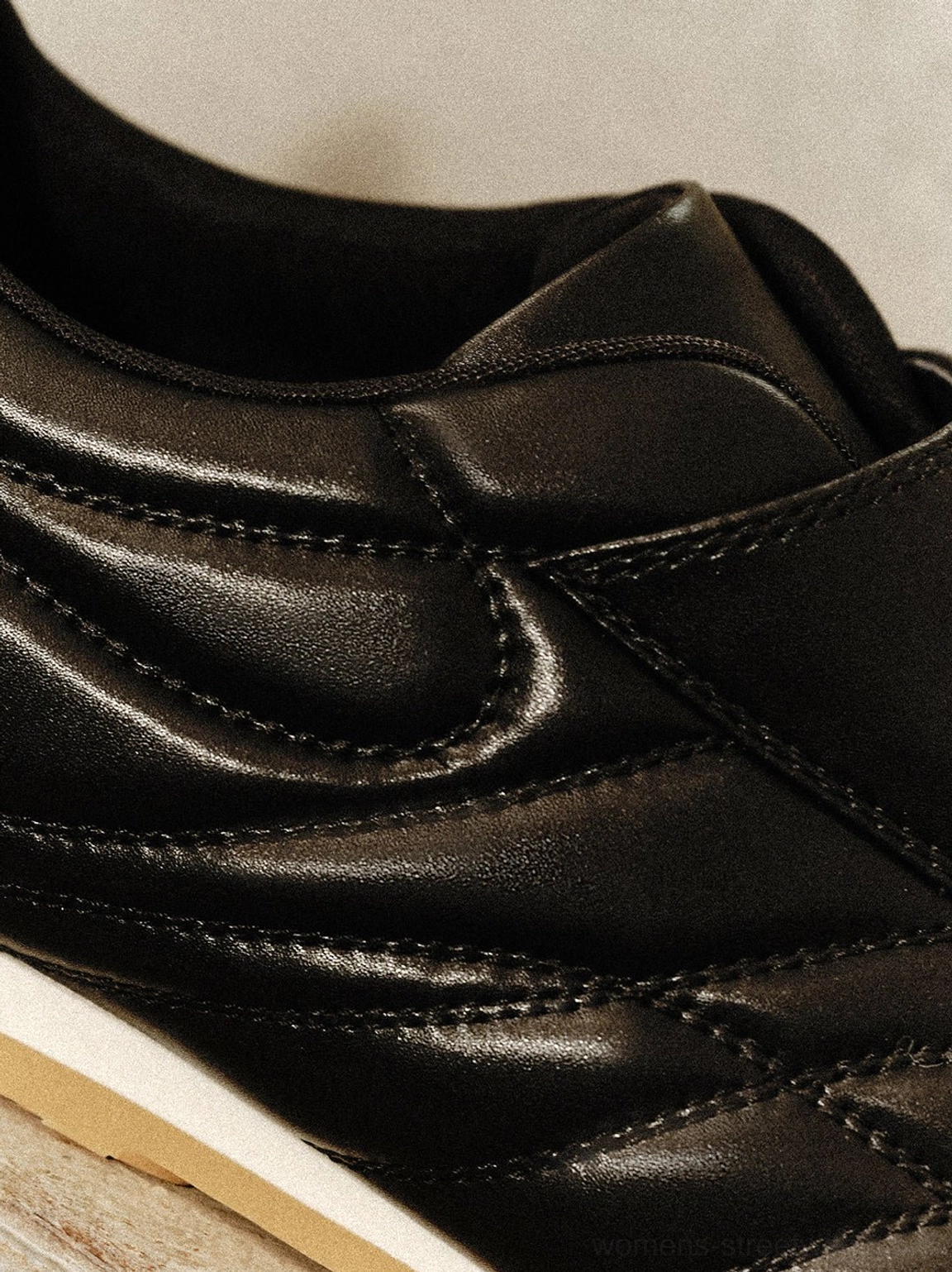 Minimalist black soccer trainer sneakers with adjustable closure and classic gum outsole for everyday city wear