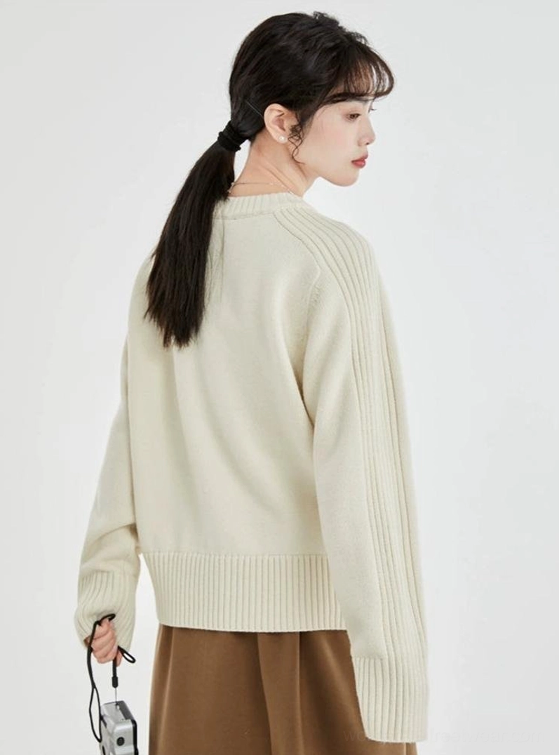Full back view of a minimalist cream ribbed sweater with relaxed drop shoulders, long sleeves, and ribbed bottom hem