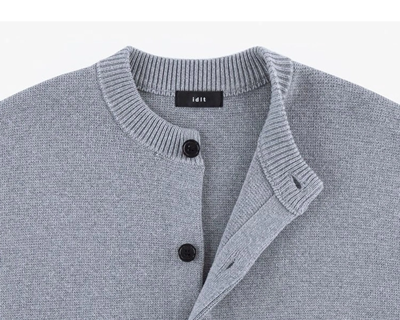 Detailed upper front view of ash gray minimalist knit cardigan with crew neckline and black buttons
