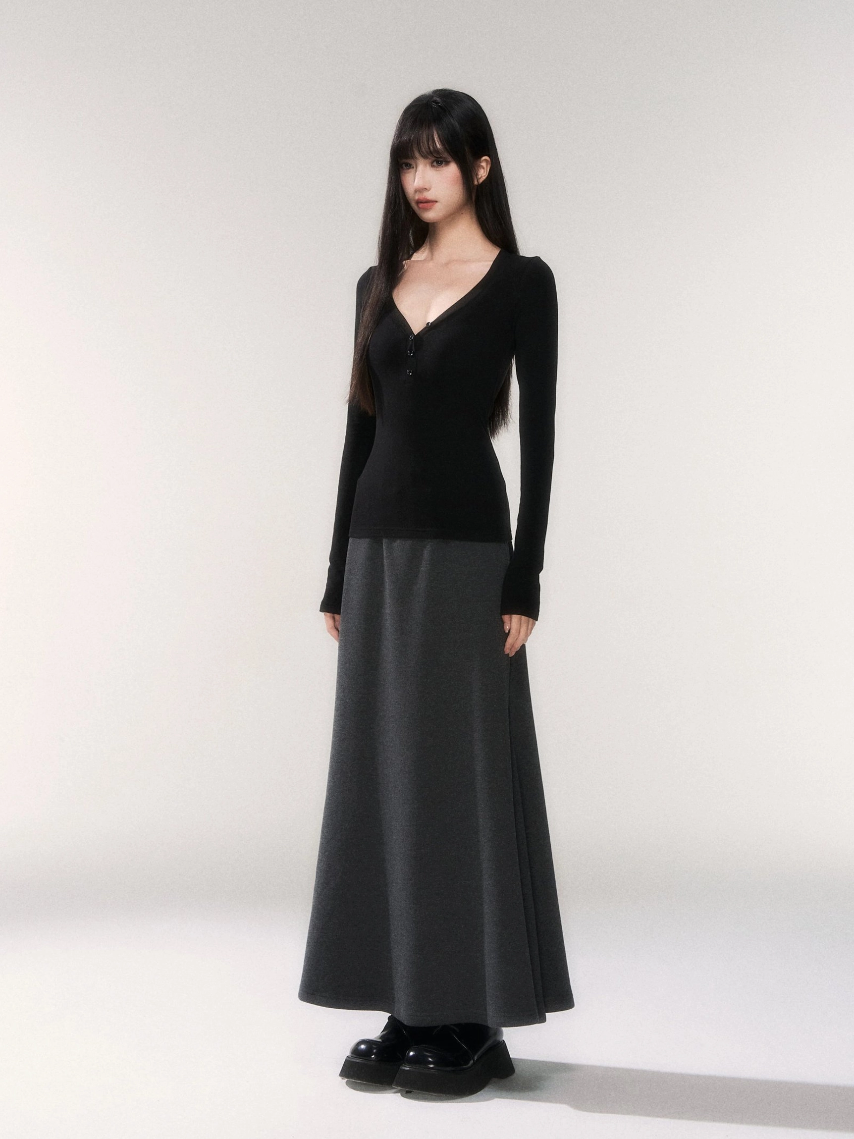 Dark gray knit fishtail maxi skirt with a fitted black V-neck top and chunky platform loafers in a Seoul minimalist streetwear outfit