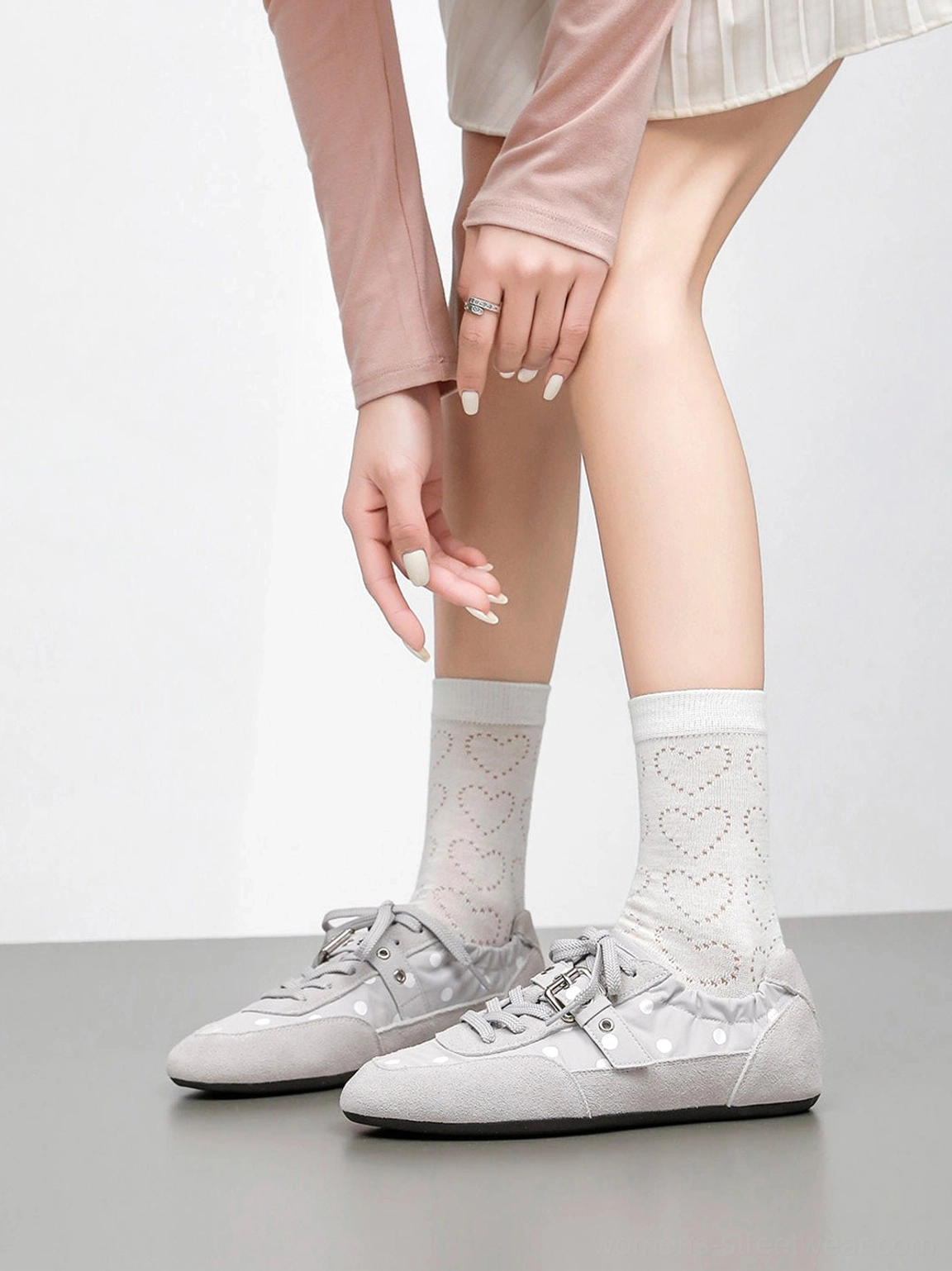 Minimalist low-profile ballet sneakers featuring a playful polka dot upper and silver-tone buckle hardware