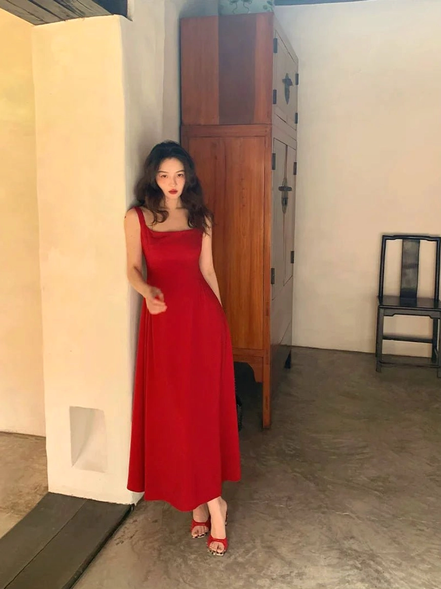 Side view of a minimalist solid red sleeveless maxi dress with square neckline, natural drape, and elegant floor length hem