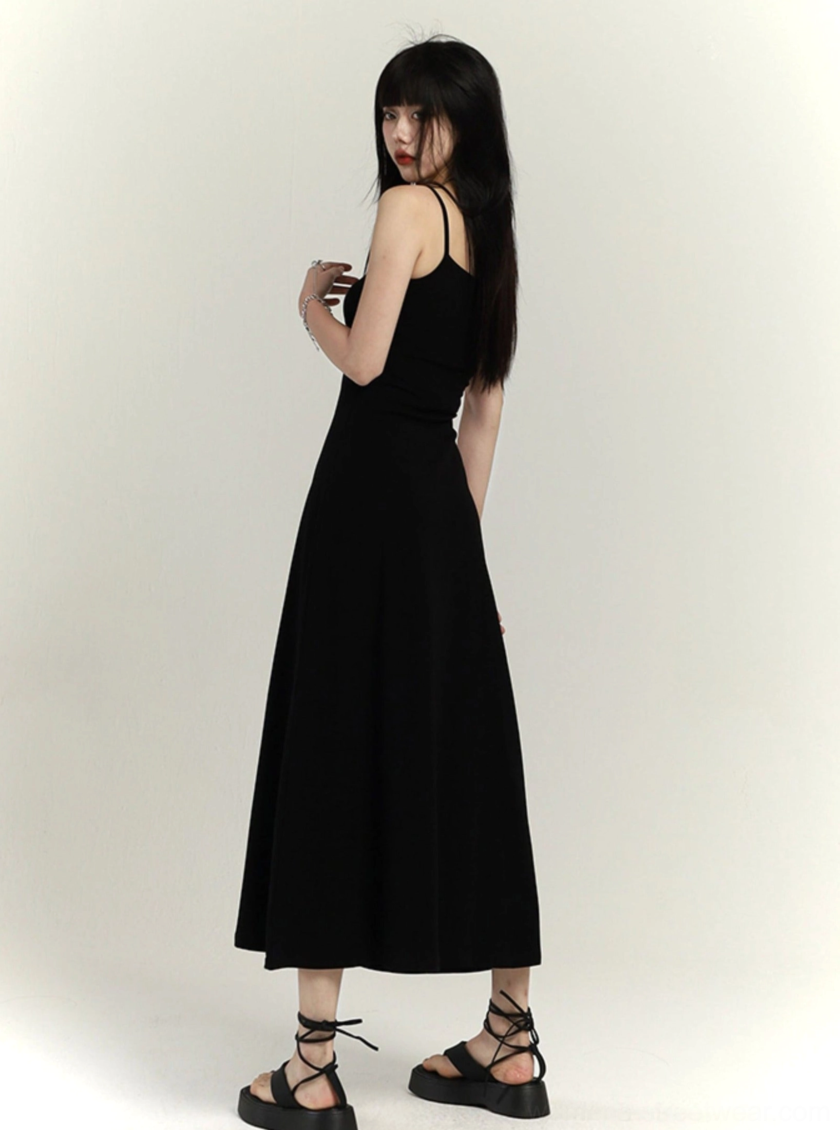 Back three-quarter view of black square neck waist-defined floor-length maxi slip dress