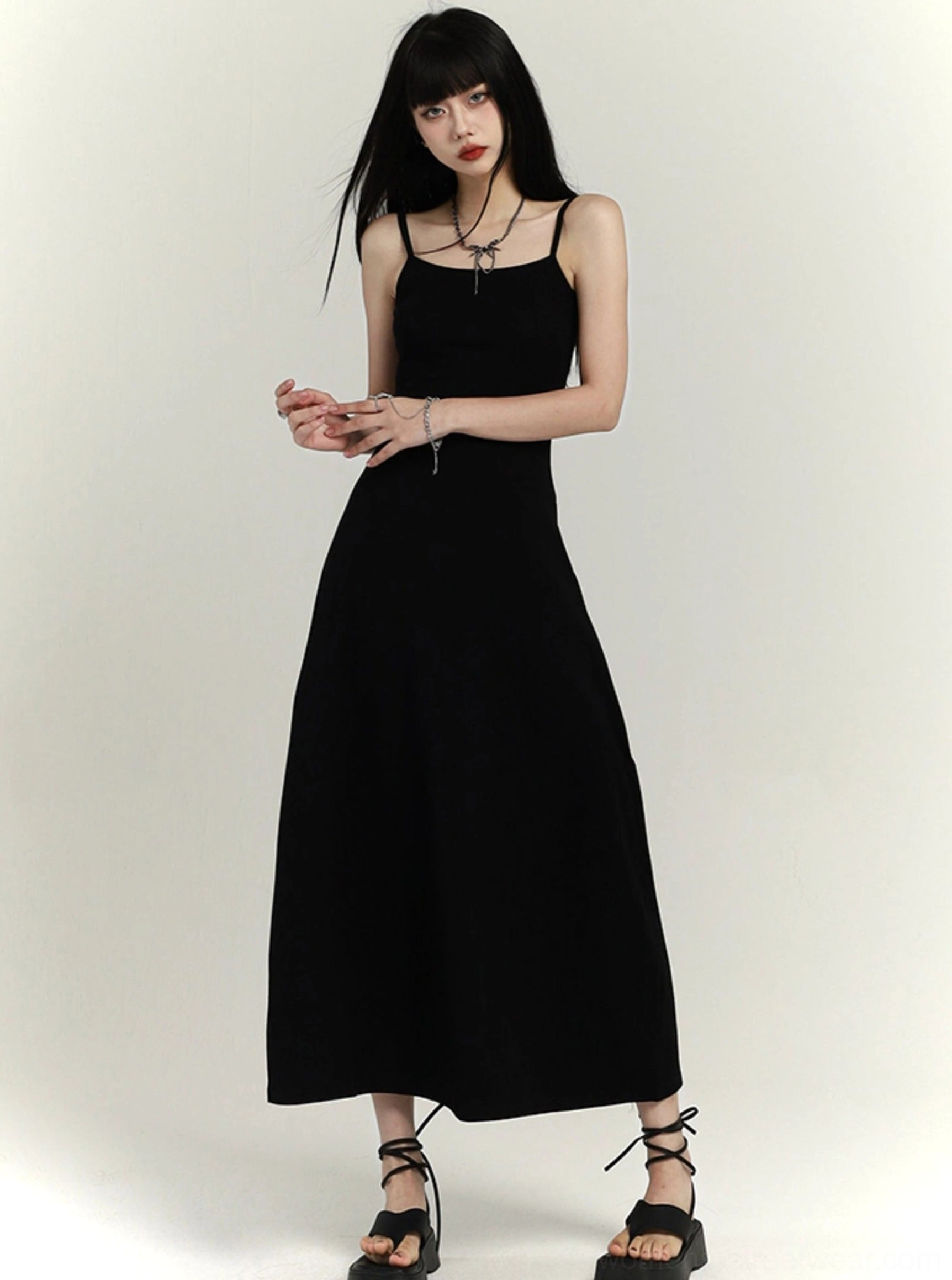 Black waist-defined maxi slip dress with delicate shoulder straps styled with black platform sandals