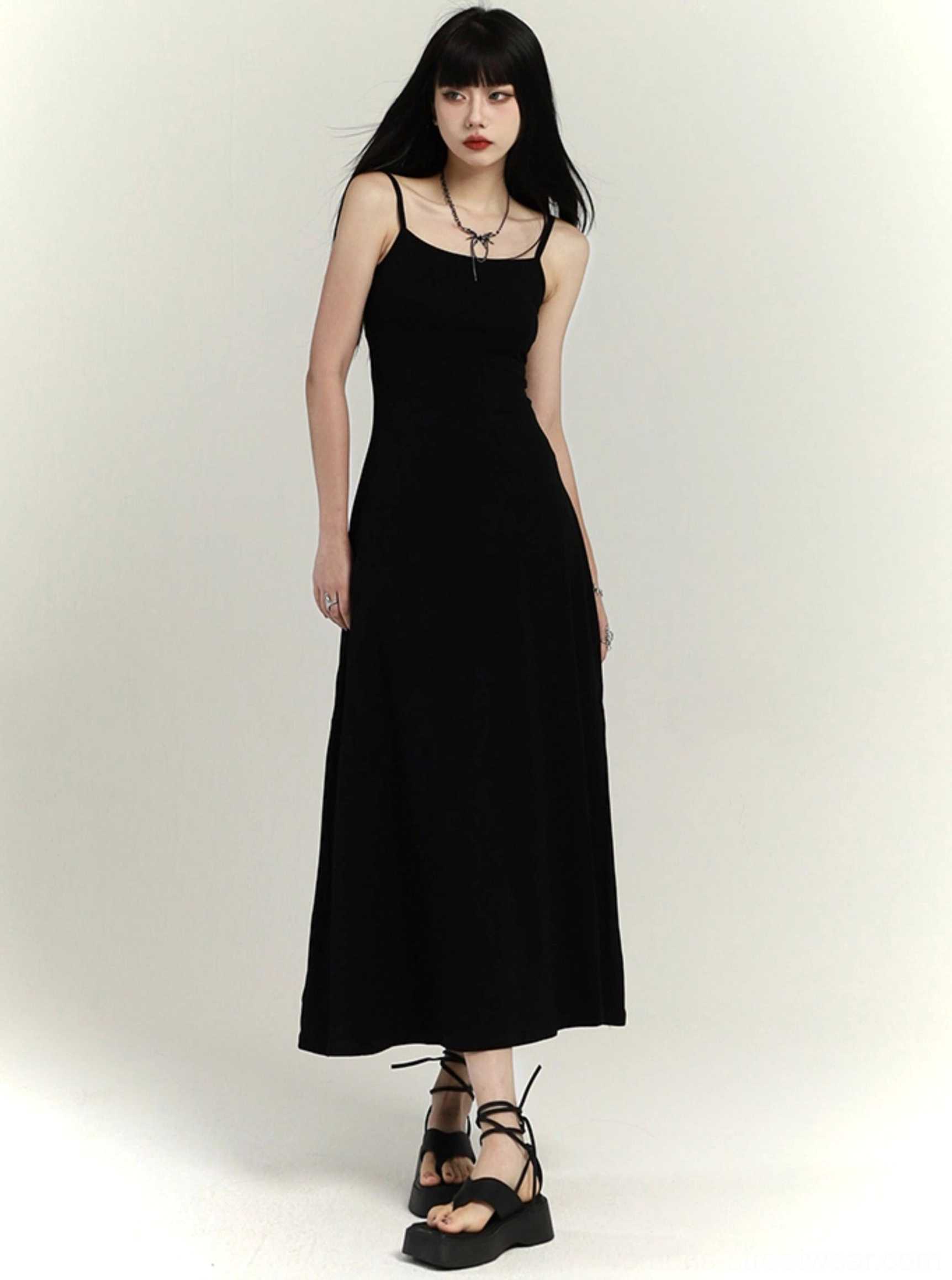 Black square neck maxi slip dress with slim waist and flared floor-length skirt front three-quarter view