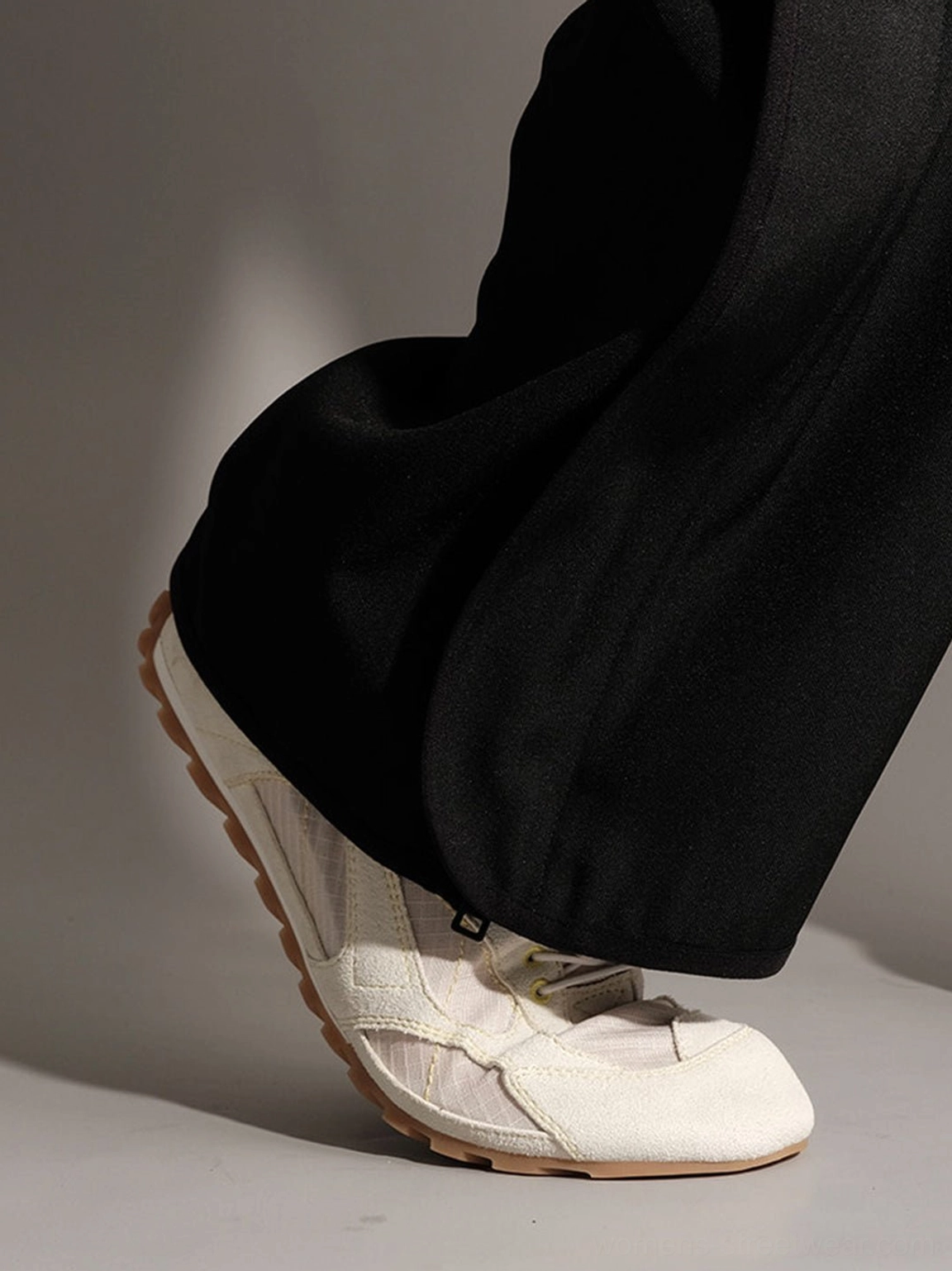 Minimalist streetwear trainers featuring rounded toe and layered stitched panels