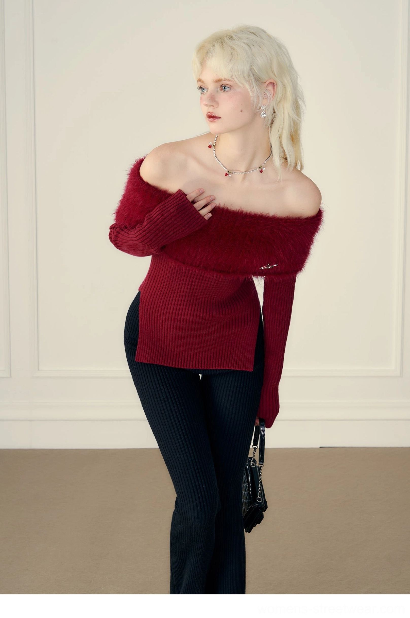 Close view of wine red ribbed off-shoulder sweater with wide fluffy trim collar and metal accent