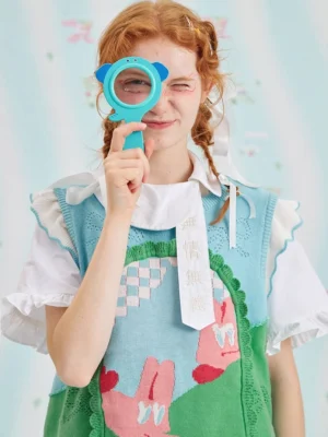 Mint green bunny jacquard knit sweater vest worn with ruffled shirt details in a playful Harajuku streetwear studio look