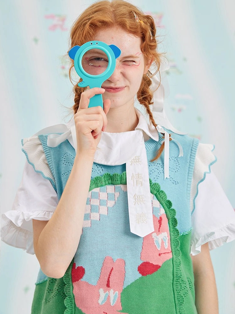 Mint green bunny jacquard knit sweater vest worn with ruffled shirt details in a playful Harajuku streetwear studio look