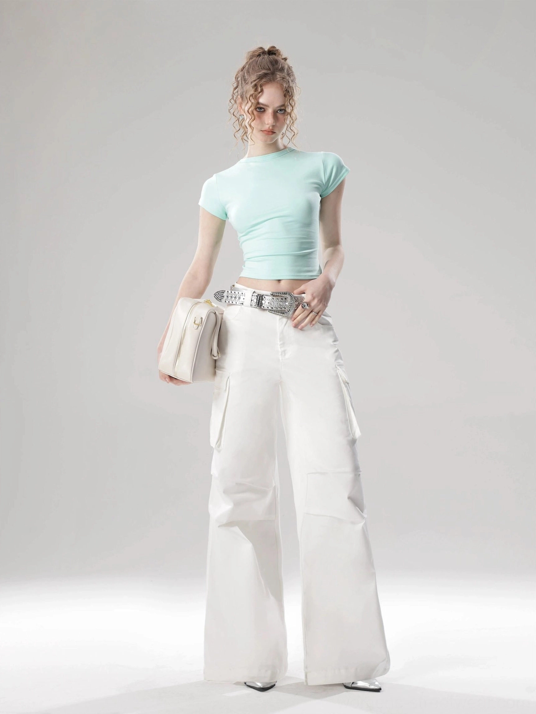 Mint green fitted cropped top with flutter sleeves styled with white cargo wide-leg pants and silver belt