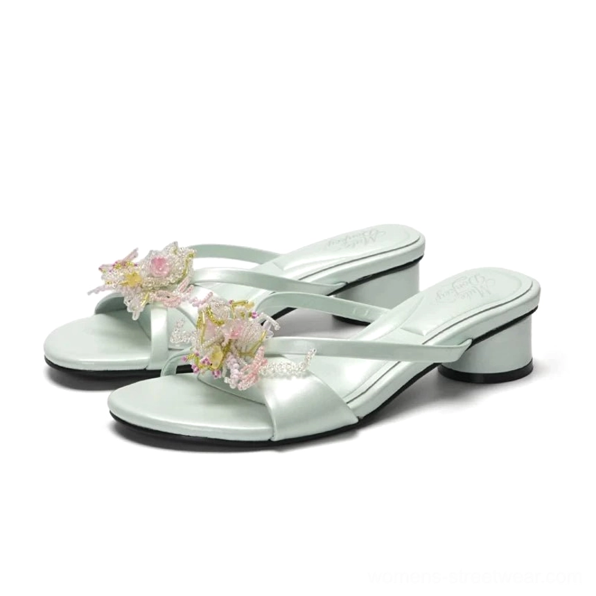 Mint green floral crystal crossover low heel mules on a clean white studio background