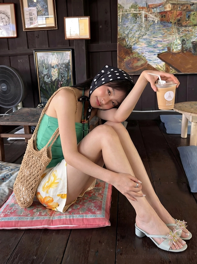 Model wearing mint green floral ribbon crossover low heel mules in a retro summer indoor outfit