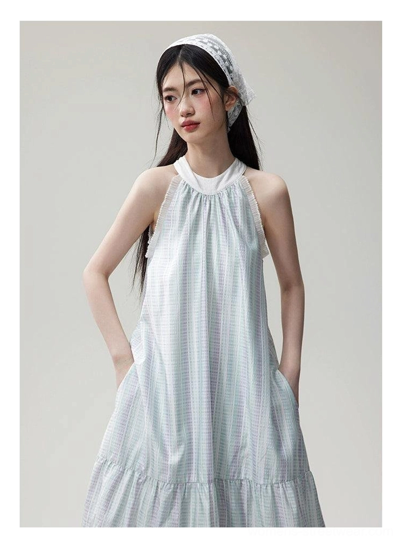 Half-body side view of a loose mint lavender check maxi dress with sleeveless halter neckline, side pocket, and flowing tiered skirt
