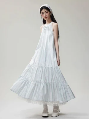 Three-quarter front view of a mint lavender gingham halter maxi dress with tiered organza skirt, lace hem, matching headband, white Mary Jane shoes, and frilled socks